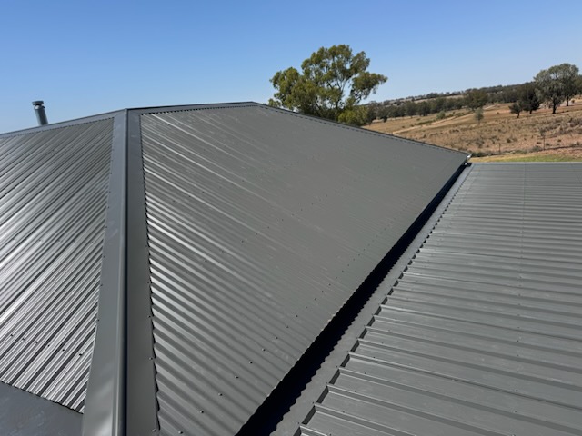 New dark grey Colorbond roof on a rural Central West home, paddocks and gum trees behind